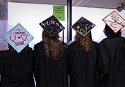 four students showing the back of their graduation caps