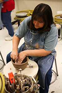 Student working at a pottery wheel
