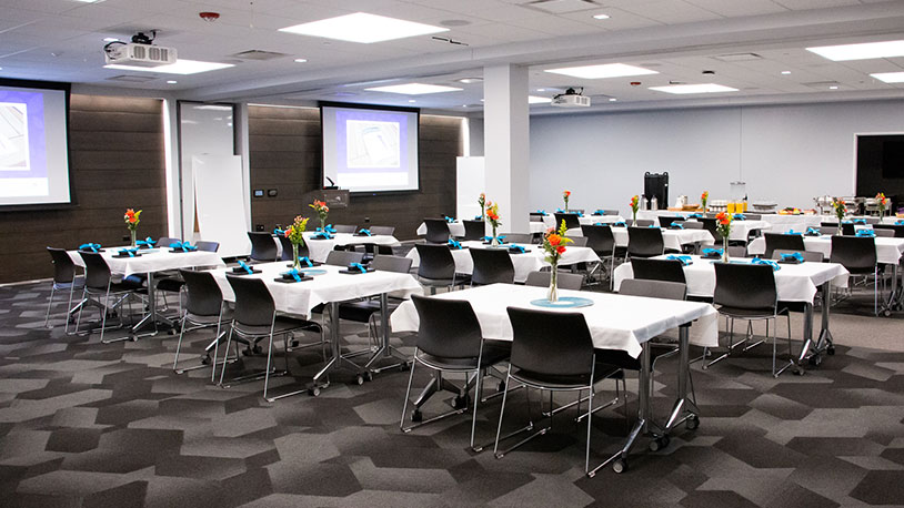 large conference room with projector and dining tables for event