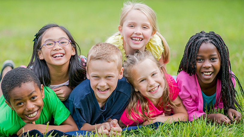 group of smiling kids on the grass