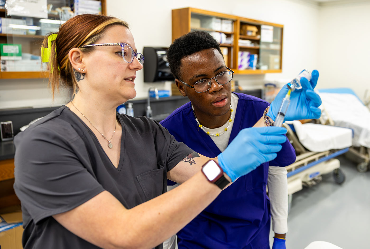 An MCC pharmacy tech instructor demonstrates how to prepare a syringe with medication for injection.