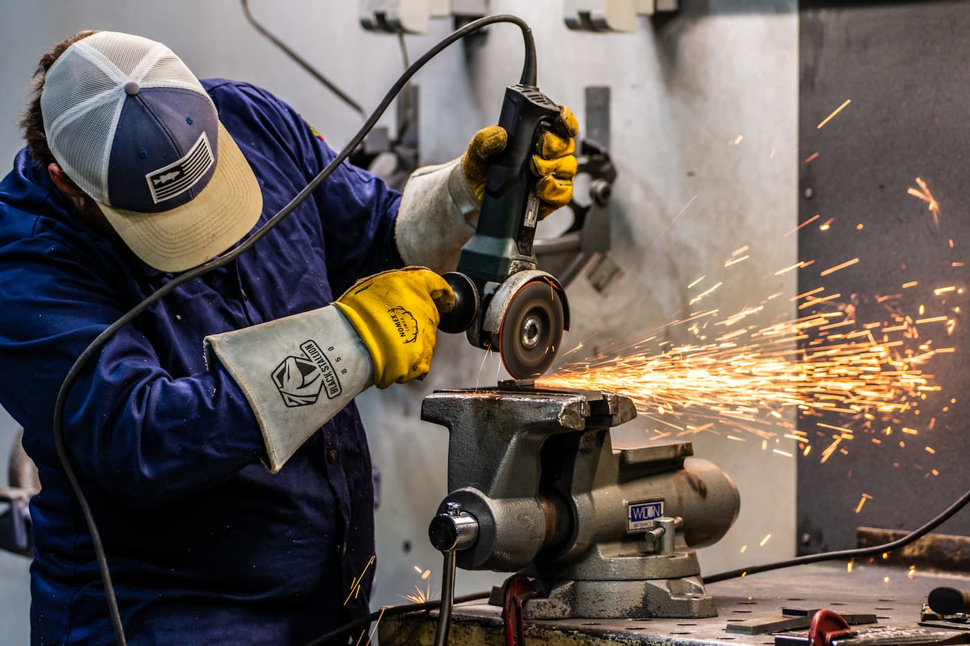 sparks fly as a student works on a welding project