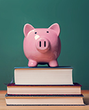A piggy bank sits atop school books