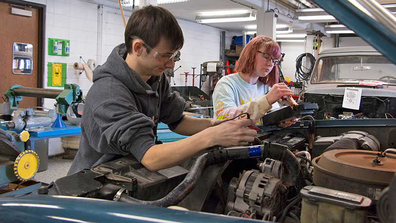 automotive students working on cars in shop