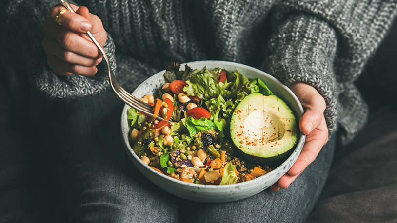 healthy grain bowl sitting on a woman's lap