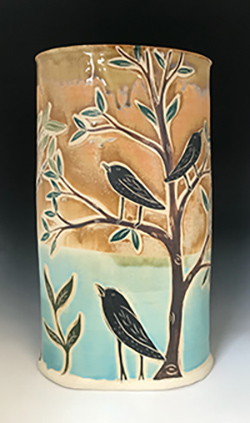 Tall vase with birds in a tree on it