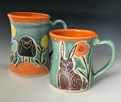 Two ceramic coffee mugs with rabbits on them